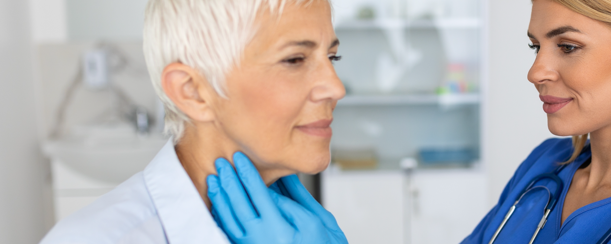 Een huisarts die een klinisch onderzoek uitvoert en de gebieden met lymfoïde organen en lymfeklieren palpeert