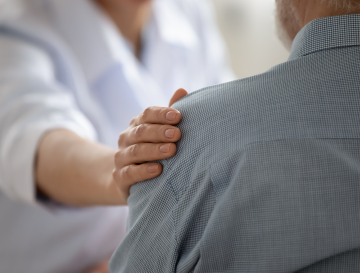 Een arts die een lymfeklierkankerpatiënt ondersteunt en verschillende behandelingsopties uitlegt